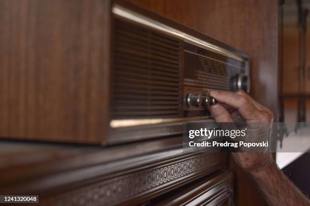 elder man hand tuning old radio - brown fotografías e imágenes de stock