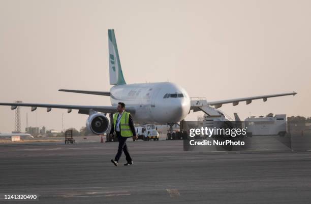 An unidentified man walks past an Iranian Mahan Air Airlines aircraft at Tehrans International Mehrabad Airport on June 14, 2022.