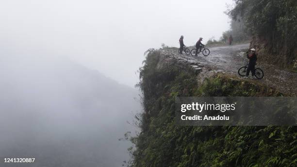 Truristas ride their bikes near a ravine on the Death Road in Los Yungas, La Paz, Bolivia on June 07, 2022. The Yungas Highway, also popularly known...