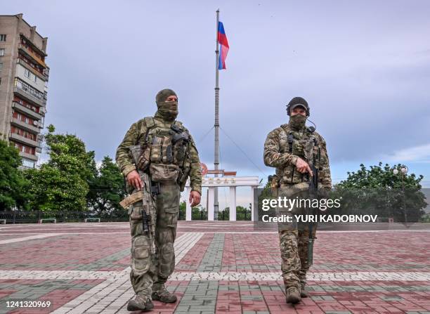 Russian servicemen patrol a square with the Russian national flag in central Melitopol, amid the ongoing Russian military action in Ukraine, on June...