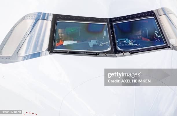 Pilots make ready for takeoff an Airbus A321XLR plane prior to its first flight from the Airbus plant in Hamburg, northern Germany, on June 15, 2022....