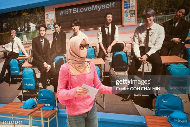 Fan poses for photos during an exhibition of artwork on K-pop group BTS in Jakarta on June 15, 2022.