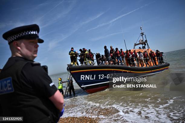 British police officer stands guard on the beach of Dungeness, on the southeast coast of England, on June 15 as Royal National Lifeboat Institution's...
