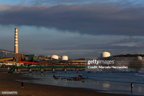 Resident walk on the beach with the Ventanas industrial park behind on June 14, 2022 in Puchuncavi, Chile. After over 100 cases of intoxication ,...