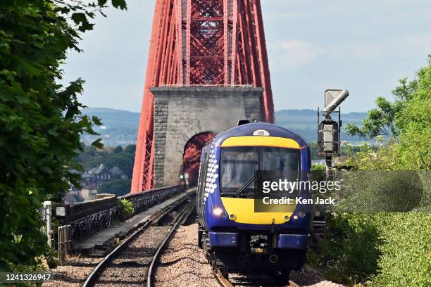 ScotRail train leaves the Forth Bridge, as the company announces it will have to cut 90% of its services on some days next week if the planned strike...