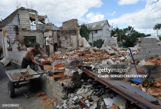 Man moves bricks during the reconstruction of a destroyed home in the small town of Makariv, Kyiv region on June 15 as the Russian-Ukraine war enters...