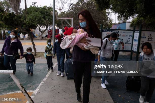 Mexican Brigitte Baltazar Lujano, a 35 year-old transgender woman, carries a baby as she walks with asylum seekers leaving a shelter and heading to...