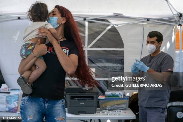 Mexican Brigitte Baltazar Lujano, a 35 year-old transgender woman, plays with a child as nurse Eduardo Moreno prepares COVID-19 tests for him and his...