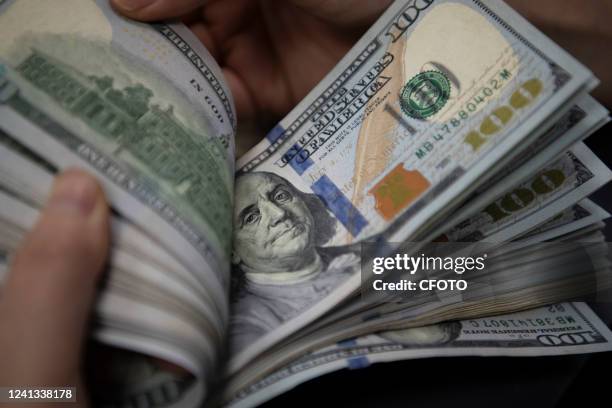 Staff member counts US dollar notes at a bank in Haian City, East China's Jiangsu Province, June 16, 2022. The US Federal Reserve raised its...