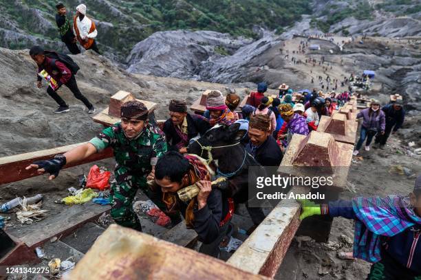 Hindus Tengger tribe people carry livestock as offerings during the Yadnya Kasada Festival at the crater of Mount Bromo on June 16 in Probolinggo,...