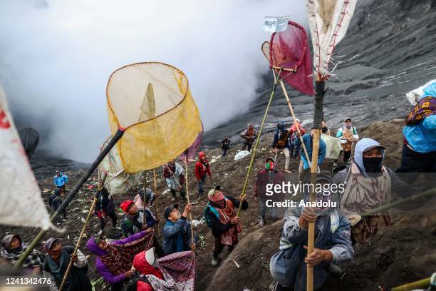 Villagers use nets to catch offerings thrown by Hindus Tengger tribe people during the Yadnya Kasada Festival at the crater of Mount Bromo on June...