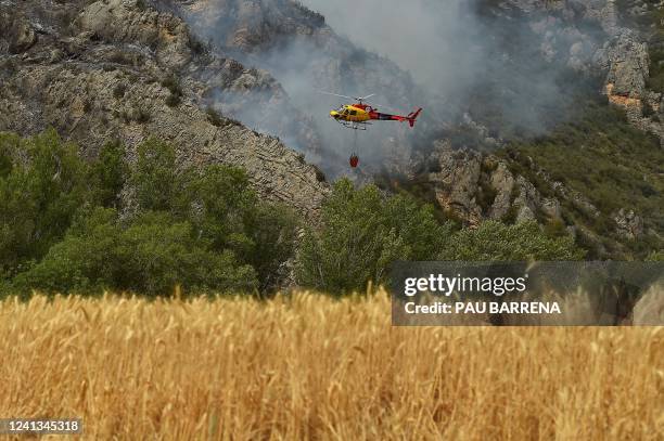 An AS-350 "Ecureuil" fire-fighting helicopter takes part in fire containment operations in Artesa de Segre, in Catalonia on June 16, 2022. -...