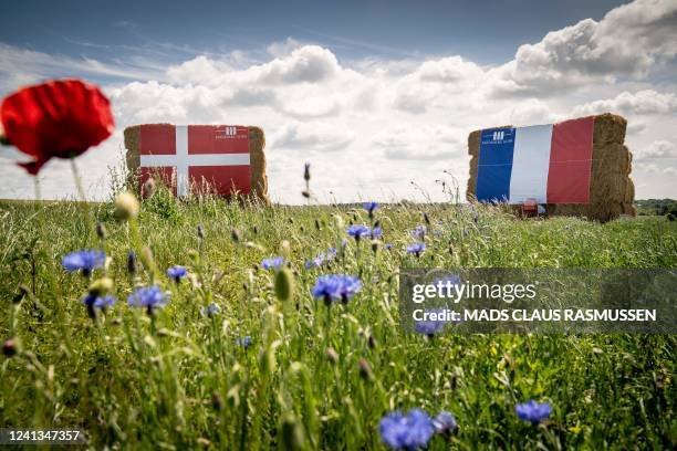 Danish and French flags hang from piles of strawballs along the route of the second stage of this year's Tour de France in the countryside in the...