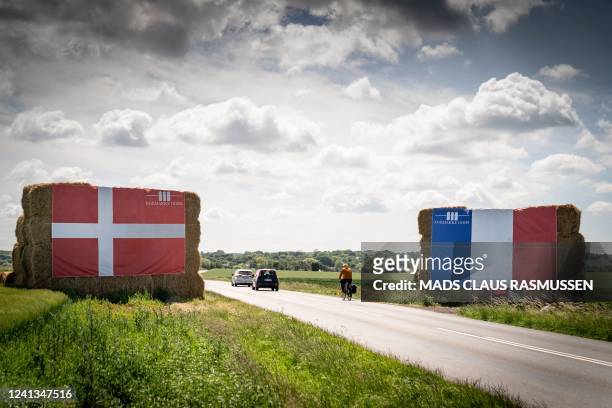 Danish and French flags hang from piles of strawballs along the route of the second stage of this year's Tour de France in the countryside in the...