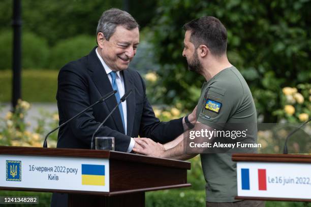 Ukrainian President Volodymyr Zelensky and Italian Prime Minister Mario Draghi shake hands after a press conference on June 16, 2022 in Kyiv,...