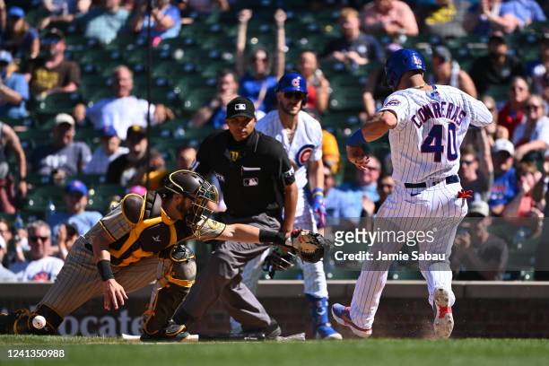 Willson Contreras of the Chicago Cubs scores from first base in the eighth inning as catcher Austin Nola of the San Diego Padres attempts to tag...