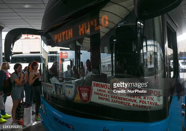 Travelers are waiting to board a Ukrainian bus to Kiev, which has a digital inscription 'Putin Huylo' on the front. A catchphrase that pokes fun and...