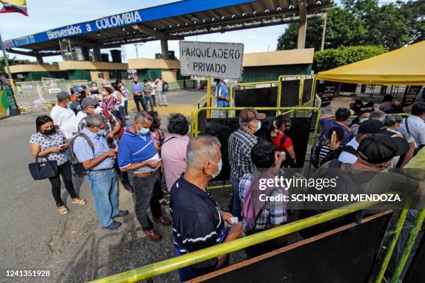 People queue during the presidential runoff election at a polling station set up at the Simon Bolivar international bridge for Colombians living...