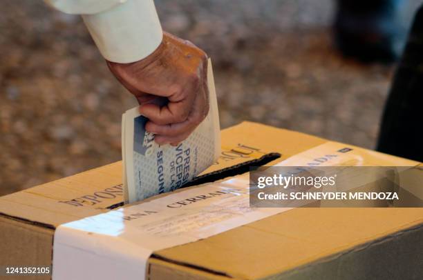 Person casts a vote during the presidential runoff election at a polling station set up at the Simon Bolivar international bridge for Colombians...