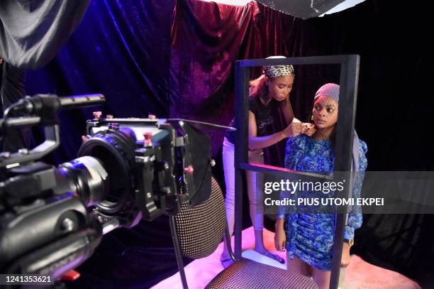 Makeup artist prepares an actress during the production of a six-minute film "Father Forgive Me" by Esther Abah at Ebonylife Creative Academy studio...