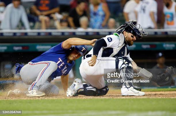 Nathaniel Lowe of the Texas Rangers scores ahead of the throw to catcher Eric Haase of the Detroit Tigers for a 3-1 lead in the ninth inning at...