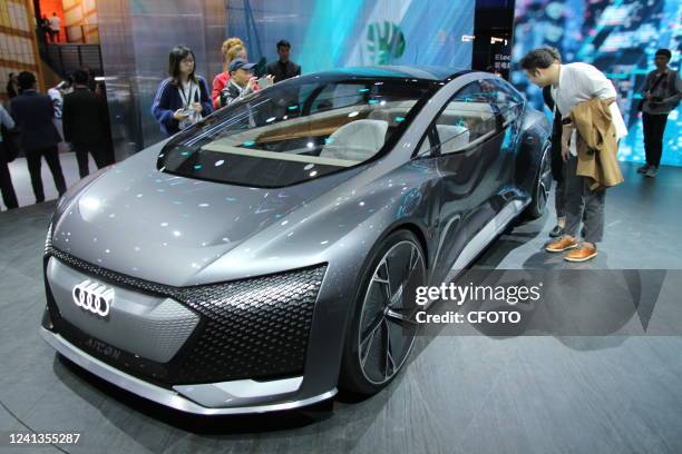 Photo taken on April 16, 2019 shows various luxury cars and a self-driving intelligent AI concept car at the Audi booth at the Shanghai International...