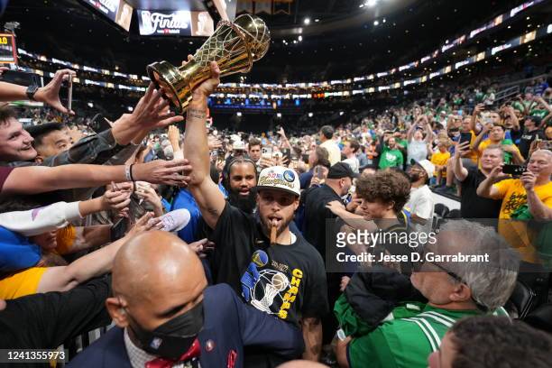 Stephen Curry of the Golden State Warriors celebrates with the Bill Russell Finals MVP Trophy after winning during Game Six of the 2022 NBA Finals on...