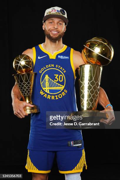 Stephen Curry of the Golden State Warriors poses for a portrait with the Larry OBrien Trophy and the Bill Russell Finals MVP Trophy after winning...