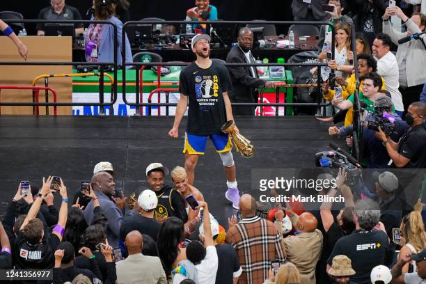 Stephen Curry of the Golden State Warriors celebrates on stage with the Bill Russell Finals MVP Trophy after winning Game Six of the 2022 NBA Finals...