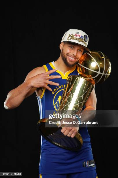 Stephen Curry of the Golden State Warriors poses for a portrait with the Larry OBrien Trophy after winning Game Six of the 2022 NBA Finals against...