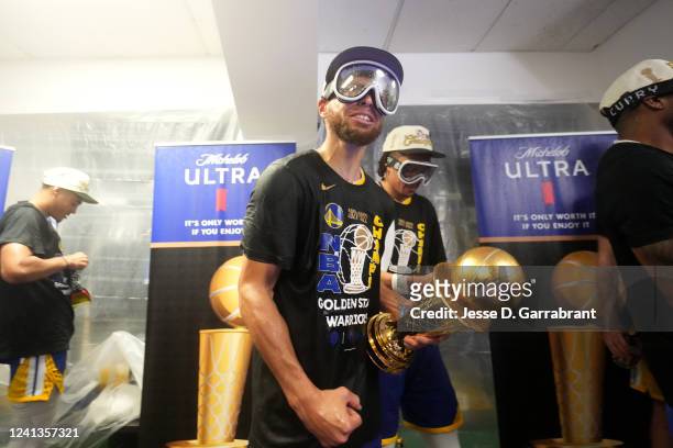 Stephen Curry of the Golden State Warriors celebrates with the Bill Russell Finals MVP Trophy after winning Game Six of the 2022 NBA Finals on June...
