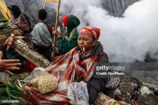 Woman use sarong to catch offerings thrown by Tenggerese worshippers during the Yadnya Kasada Festival at the crater of Mount Bromo on June 16, 2022...