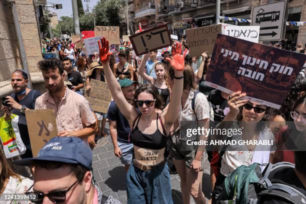 Israeli activists chant slogans and carry placards during the 10th annual "SlutWalk" march through central Jerusalem on June 17, 2022 to protest...