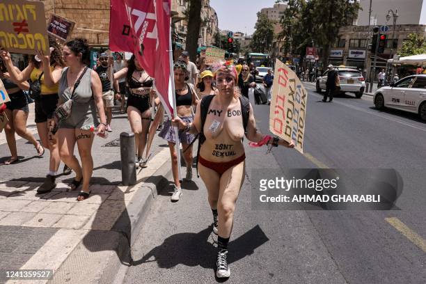 Graphic content / Israeli activists chant slogans and carry placards during the 10th annual "SlutWalk" march through central Jerusalem on June 17,...