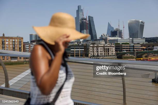 Pedestrian wearing a sunhat crosses the Millennium Bridge in London, UK, on Friday, June 17, 2022. UK temperatures may hit 34 degrees Celsius this...