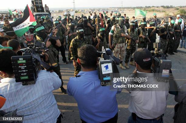 Armed Palestinian Hamas militants, holding up Islamic and Palestinian national flags, demonstrate in the former Jewish settlement of Dugit in the...