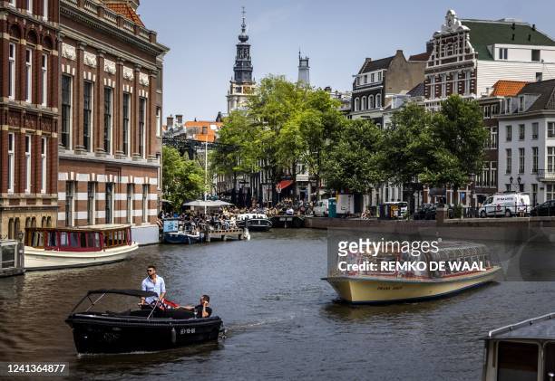 Passengers ride on a tour boat along a canal in Amsterdam on June 17 as a heatwave spreads across Europe. - - Netherlands OUT / Netherlands OUT