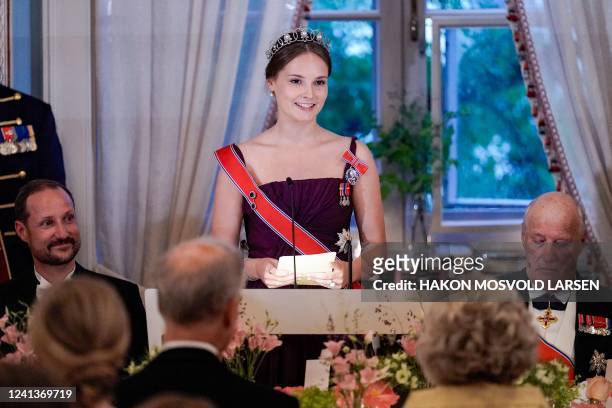 Norway's Princess Ingrid Alexandra delivers a speech next to Norway's King Harald V and Norway's Crown Prince Haakon during a gala dinner for her...