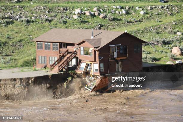 In this handout photo provided by the National Park Service, employee housing falls into Yellowstone River during heavy flooding on June 13, 2022 in...