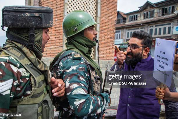 Indian paramilitary forces and Kashmiri men scuffle during a demonstration. Indian authorities demolished the house of young Muslim activist Afreen...