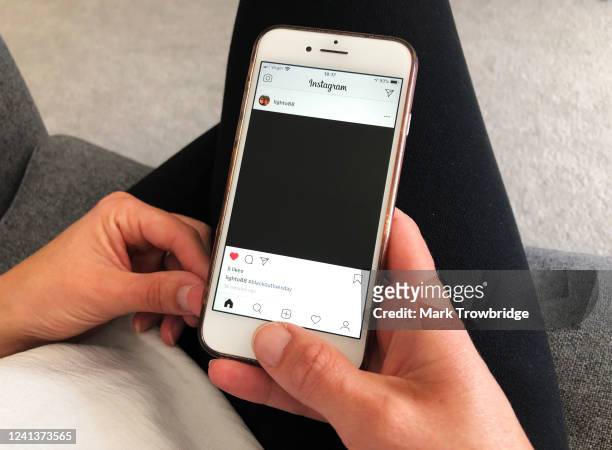 In this photo illustration, the photographer's wife looks at her husband's Instagram post for the #blackouttuesday social media campaign, showing...