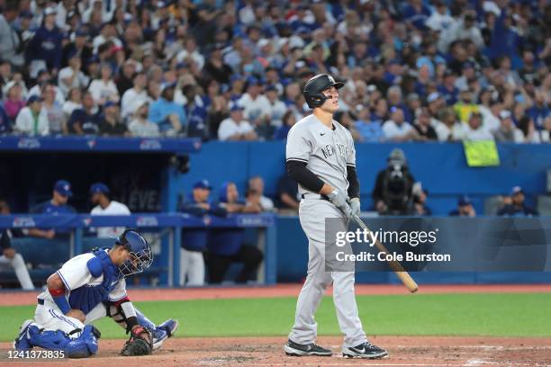 Gabriel Moreno of the Toronto Blue Jays looks to the ground as Anthony Rizzo of the New York Yankees watches his ball after hitting a grand slam in...