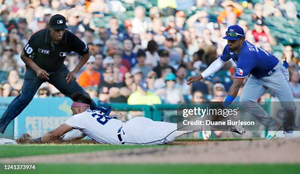 Victor Reyes of the Detroit Tigers is tagged out by third baseman Ezequiel Duran of the Texas Rangers trying to advance from first base on a hit by...