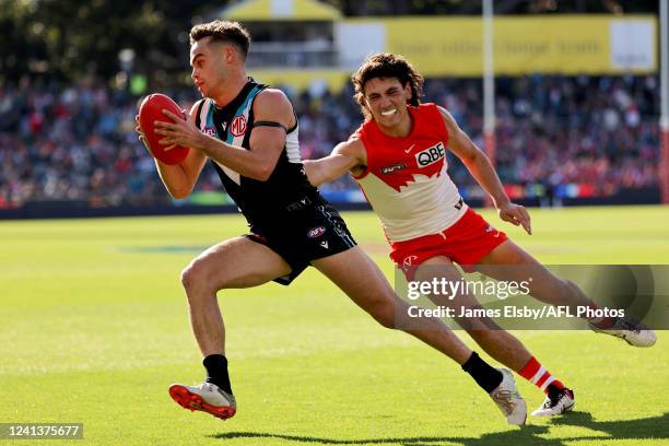 Karl Amon of the Power is tackled by Justin McInerney of the Swans during the 2022 AFL Round 14 match between the Port Adelaide Power and the Sydney...