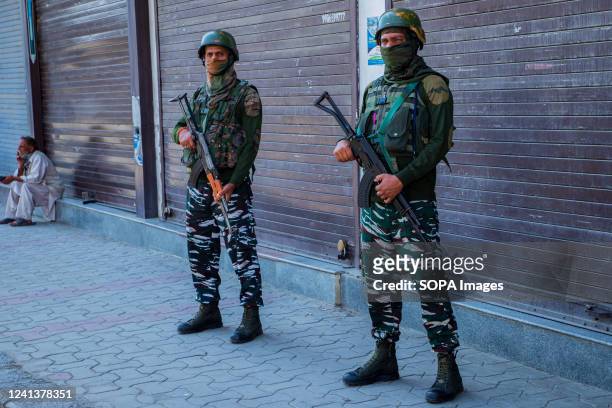 Indian paramilitary troopers stand on guard in front of closed shops during a shutdown in Srinagar over the derogatory remarks made by two now-sacked...