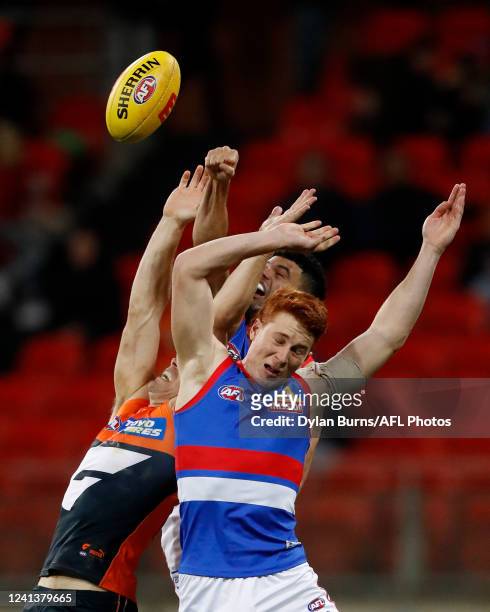 Ed Richards of the Bulldogs, Toby Greene of the Giants and Jason Johannisen of the Bulldogs compete for the ball during the 2022 AFL Round 14 match...