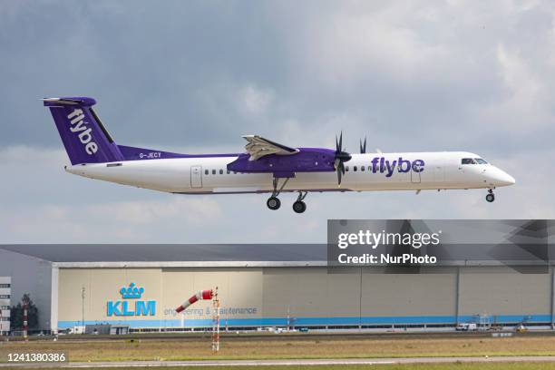 Flybe Bombardier DHC-8-400 turboprop aircraft as seen landing at Amsterdam Schiphol Airport arriving from London Heathrow Airport LHR. The airplane...