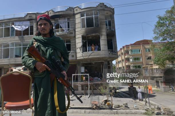 Taliban fighter stands guard in front of a Sikh temple following an attack by gunmen in Kabul on June 18, 2022. - Gunmen stormed a Sikh temple in the...