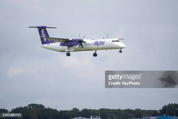 Flybe Bombardier DHC-8-400 turboprop aircraft as seen landing at Amsterdam Schiphol Airport arriving from London Heathrow Airport LHR. The airplane...