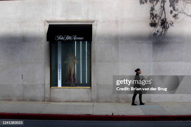 June 16, 2022: A woman walks past a window at Saks Fifth Avenue store, one of Beverly Hills most famous department stores, is set to move to make way...